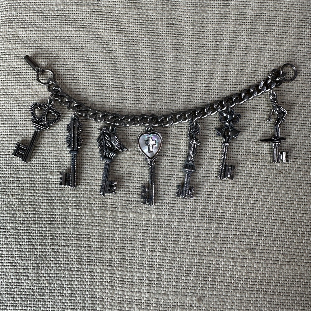 Vintage silver charm bracelet with the 7 key charms, 7 inches long